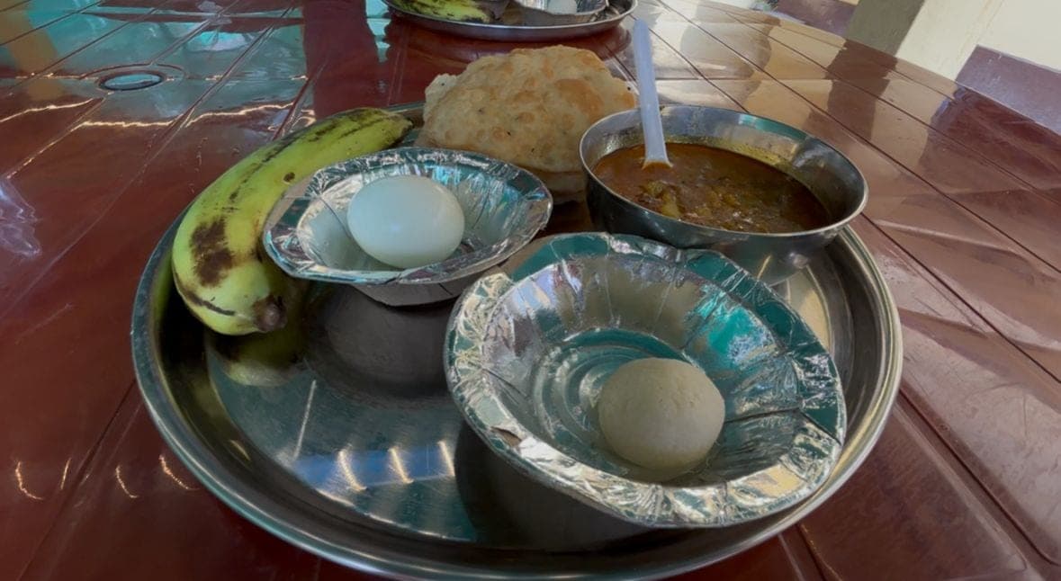 Breakfast plate with banana, egg, bread, and curry