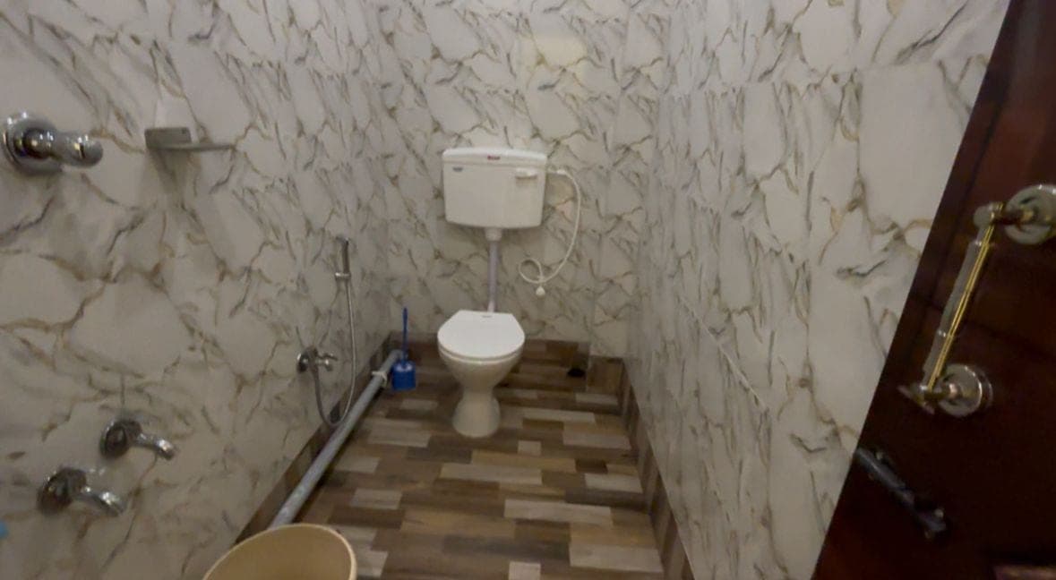 Bathroom with marble-look tiles, shower, and toilet