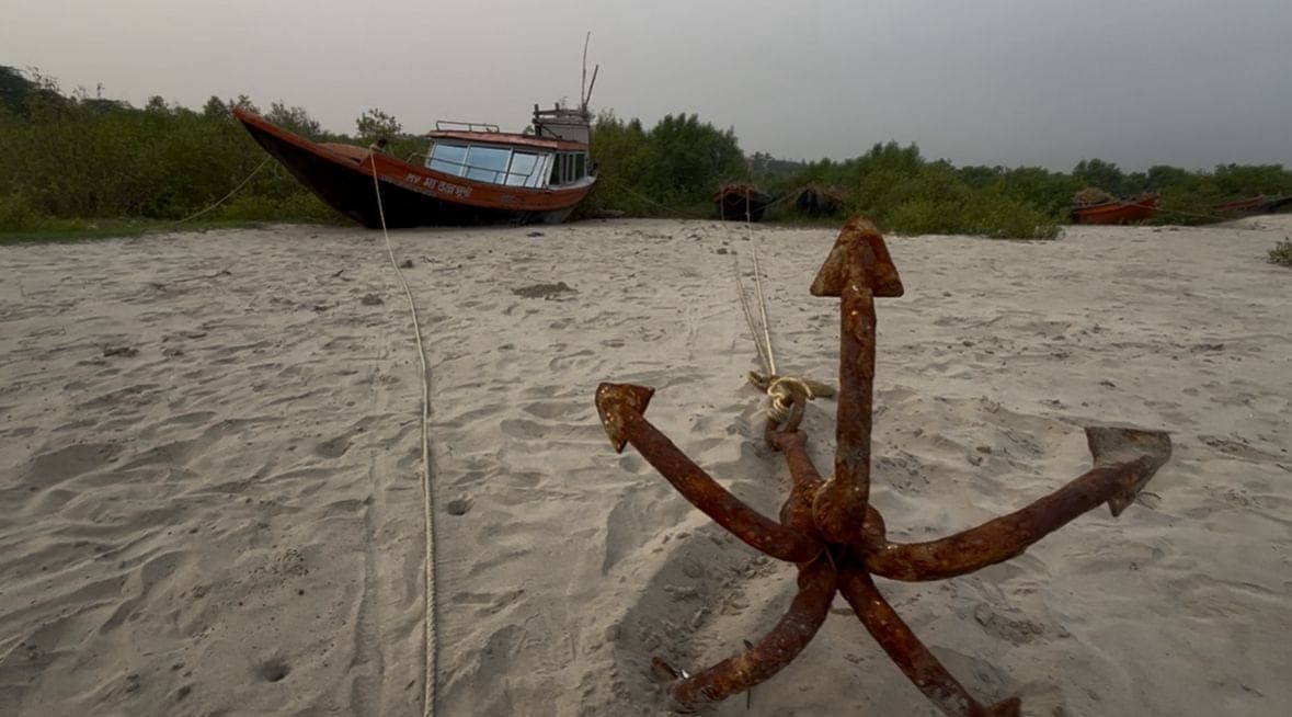 Fishing boats and a rusted anchor on the sand near Mousuni Island