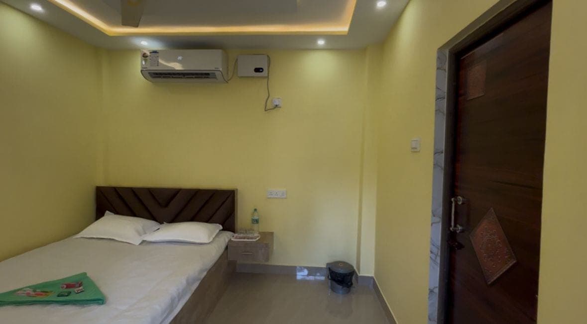 One-bed room with the door and bedside in view