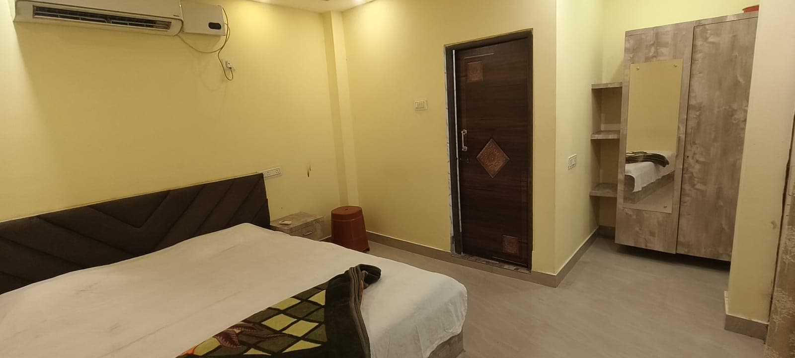 One-bed room with wardrobe, door, and air-conditioner